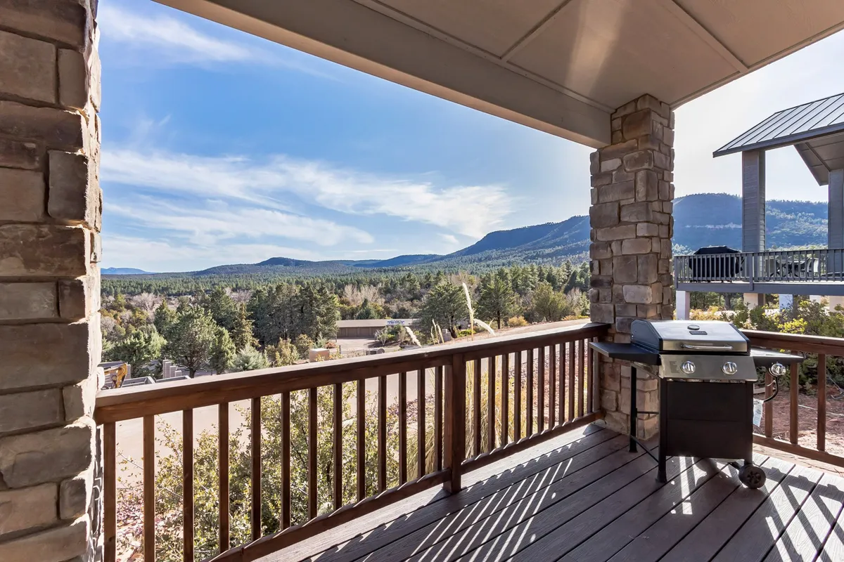 A wide deck area featuring a grill and unobstructed views of the mountains. The deck is spacious and designed for outdoor dining and gatherings, with plenty of room to enjoy sunrise coffees or host al fresco meals. The natural surroundings and open sky highlight the seamless connection to the outdoors.
