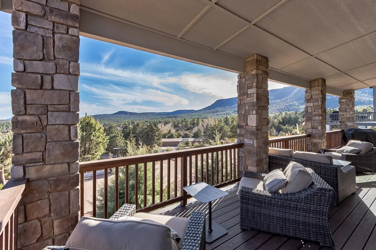 A calm, tranquil outdoor seating area with stone pillars and sweeping mountain views. The furniture hints at moments spent unwinding after a day out, while the open vista connects guests to the broader environment of Pine.