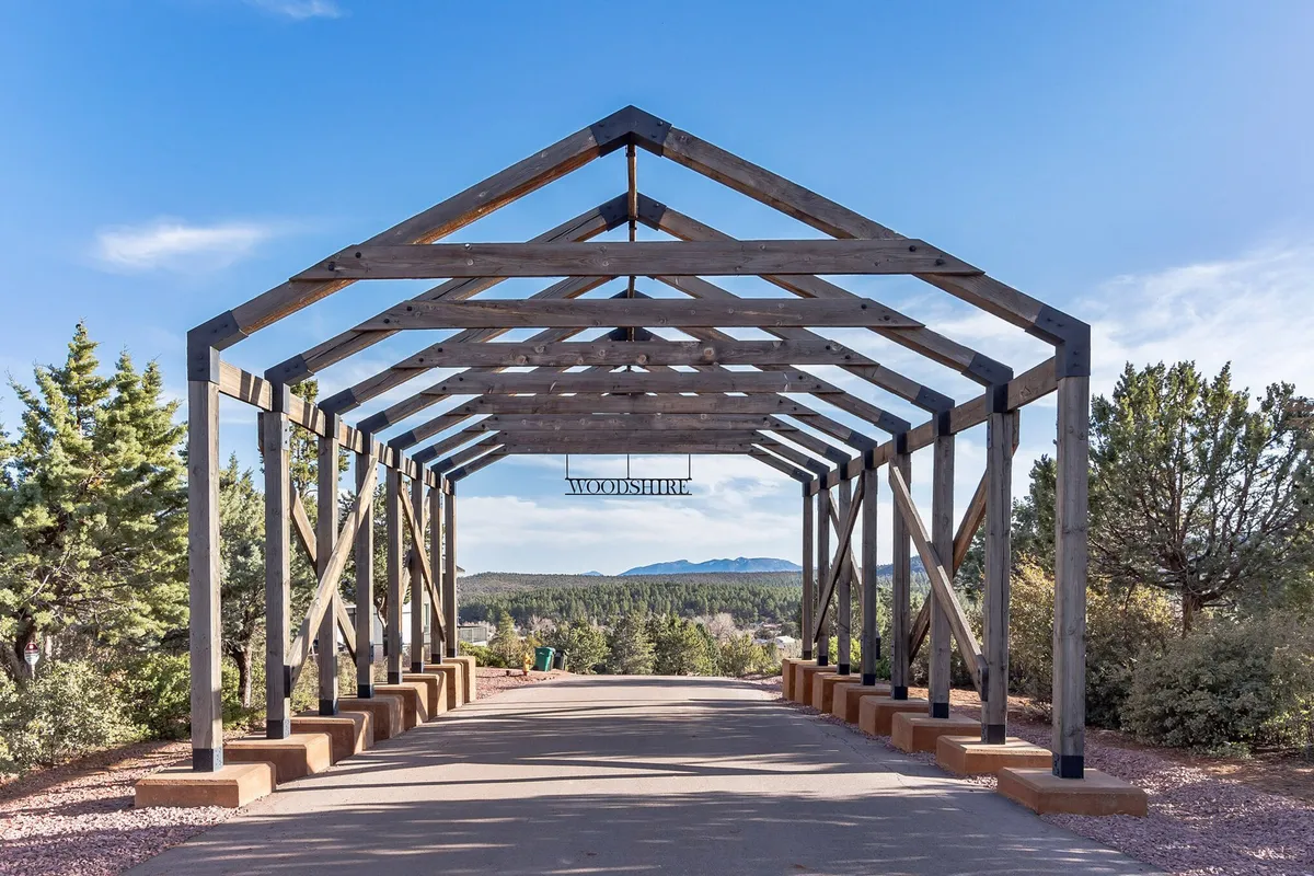 A view of the property’s wooden structure set against a picturesque mountain backdrop, with a pathway leading toward the home. The scene conveys a sense of arrival and immersion in nature, highlighting the retreat's tranquil, secluded setting.